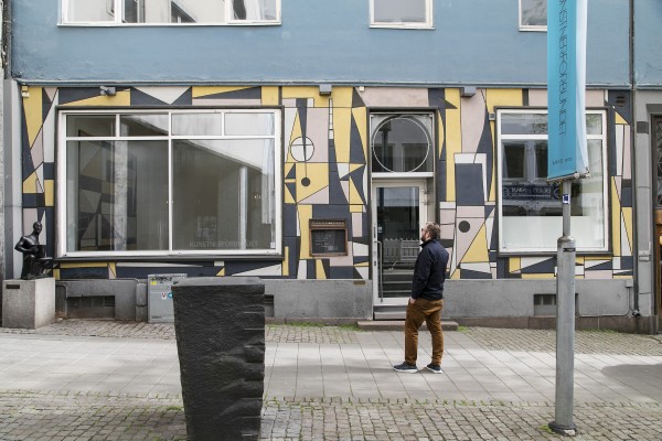 Kunstneren Anders Sletvold Moe utenfor Kunstnerforbundet hvor han betrakter fasaden og sitt maleri innenfor vinduet. (FOTO: THOMAS TVETER)